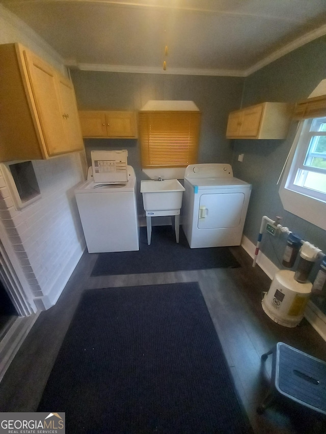 laundry room with cabinet space, ornamental molding, dark wood-type flooring, independent washer and dryer, and a sink