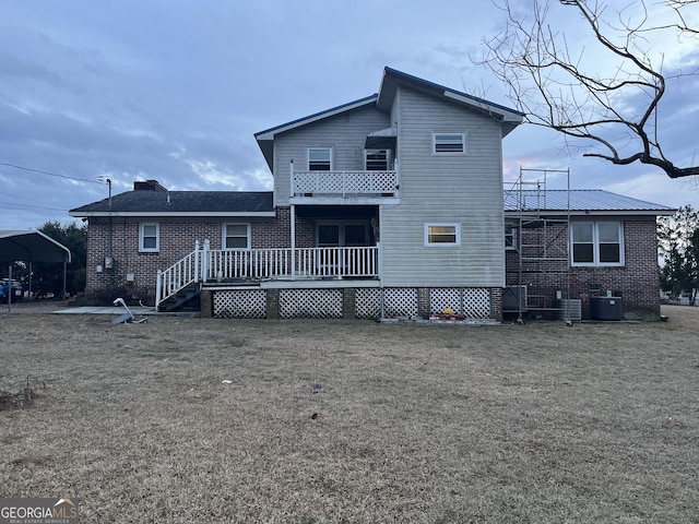 back of house featuring brick siding and central AC unit