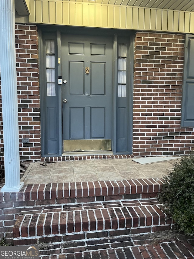 property entrance with brick siding