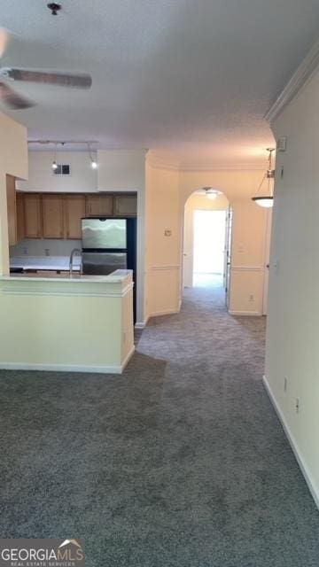 kitchen featuring rail lighting, sink, stainless steel fridge, dark carpet, and crown molding