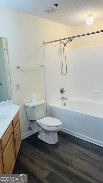 full bathroom featuring toilet, shower / bathing tub combination, a textured ceiling, vanity, and hardwood / wood-style flooring