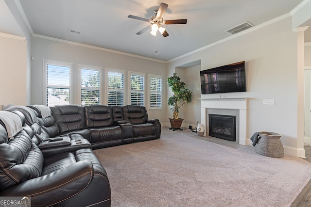 living room with a tile fireplace, carpet, ornamental molding, and ceiling fan