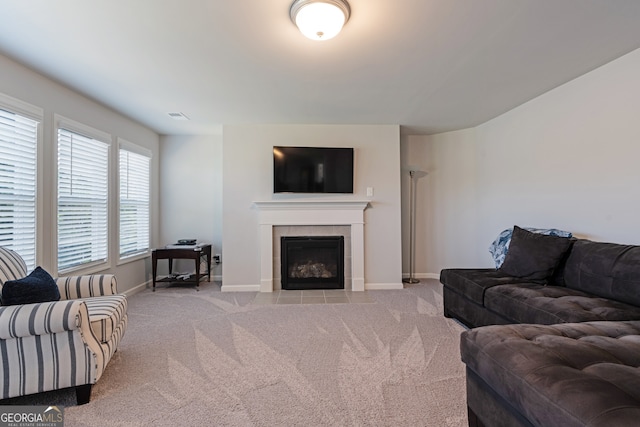 living room featuring a tile fireplace and light colored carpet