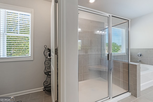 bathroom featuring tile patterned flooring, independent shower and bath, and a healthy amount of sunlight