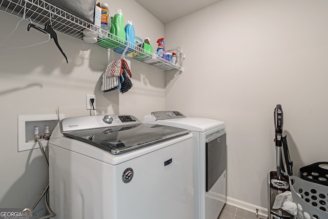 laundry area featuring washer and dryer and light tile patterned flooring