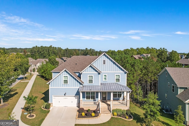 view of front of house with a garage, covered porch, and a front lawn