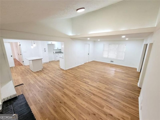 basement featuring light hardwood / wood-style floors and a textured ceiling