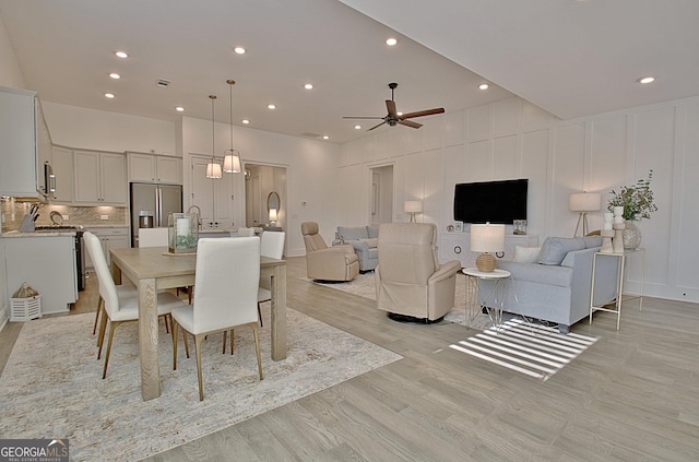 dining area with ceiling fan and light wood-type flooring