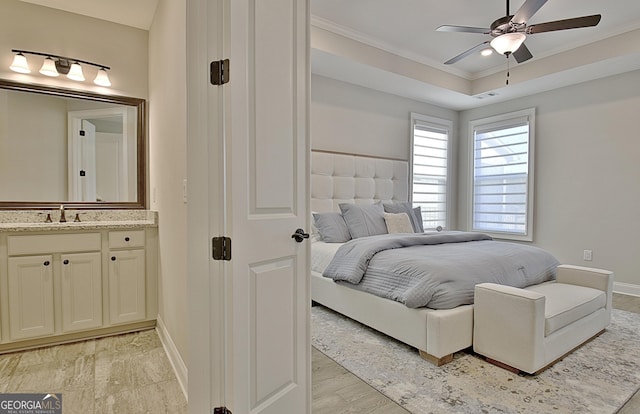 bedroom featuring connected bathroom, sink, ceiling fan, crown molding, and light hardwood / wood-style flooring