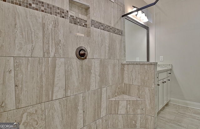 bathroom featuring a tile shower and vanity