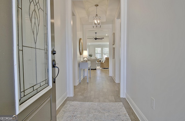 foyer entrance with ceiling fan with notable chandelier and light hardwood / wood-style floors