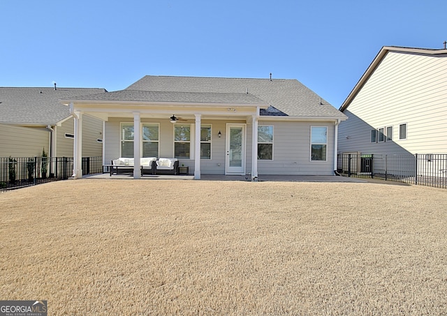 rear view of house with an outdoor living space, a yard, a patio area, and ceiling fan