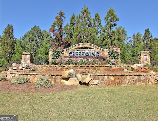 community / neighborhood sign featuring a lawn