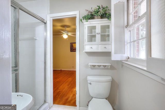 bathroom featuring hardwood / wood-style flooring, an enclosed shower, ceiling fan, and toilet