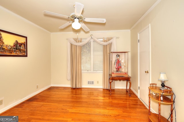 interior space featuring ceiling fan, ornamental molding, and light wood-type flooring