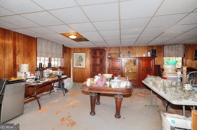 dining room featuring wooden walls and a paneled ceiling