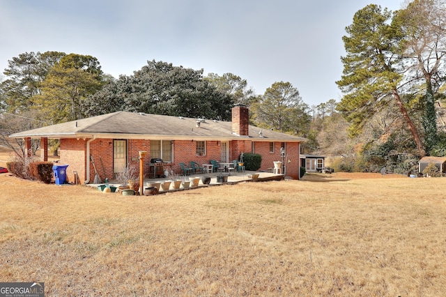 rear view of house with a lawn and a patio