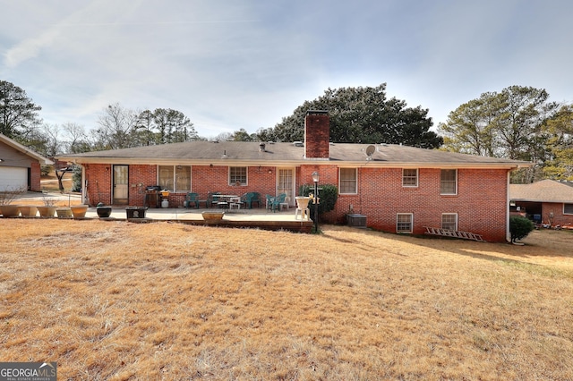 rear view of property with a lawn, a patio, and central air condition unit