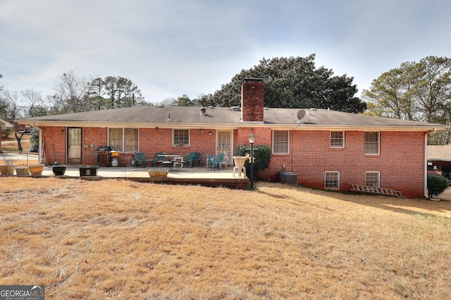 back of property featuring cooling unit, a yard, and a patio