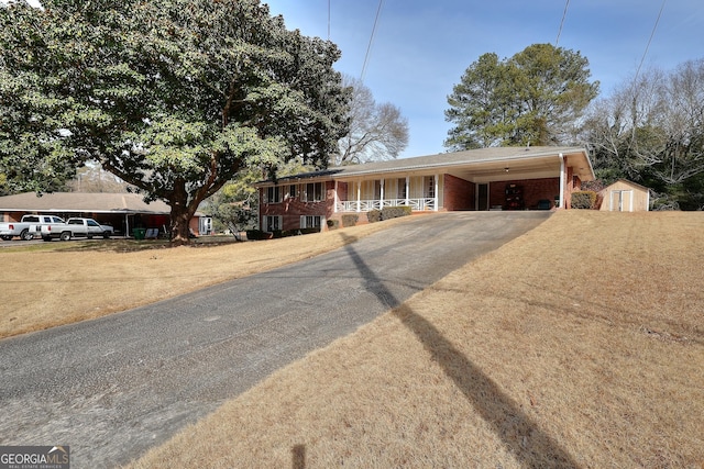 view of front of property with a carport and a storage shed