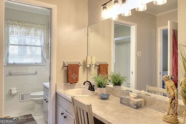 bathroom with tile patterned floors, toilet, tile walls, ornamental molding, and vanity