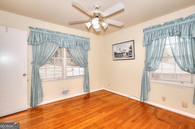 spare room with hardwood / wood-style flooring, plenty of natural light, and ceiling fan