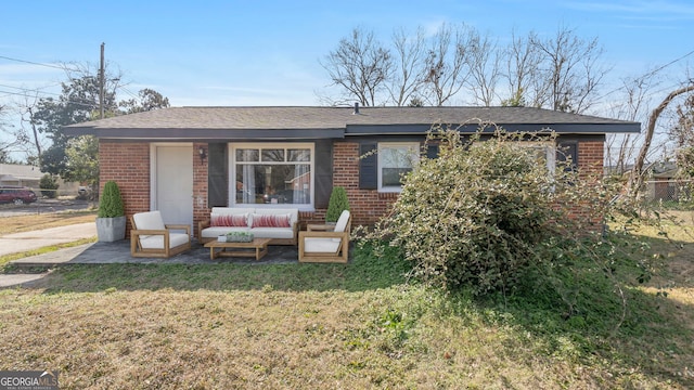 rear view of property featuring an outdoor hangout area, a patio area, and a lawn