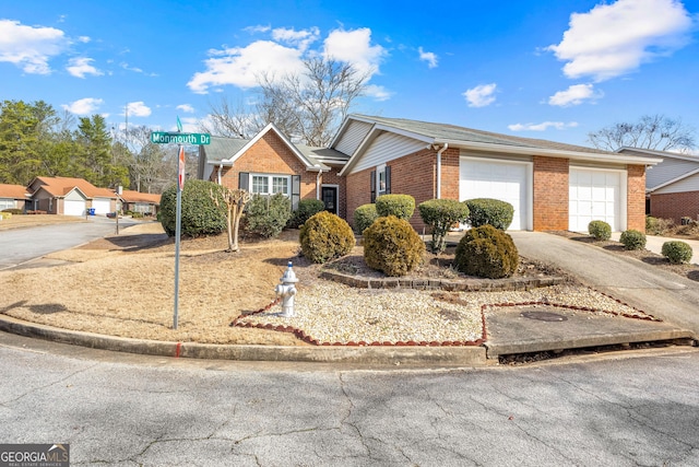 view of front facade with brick siding, an attached garage, and driveway