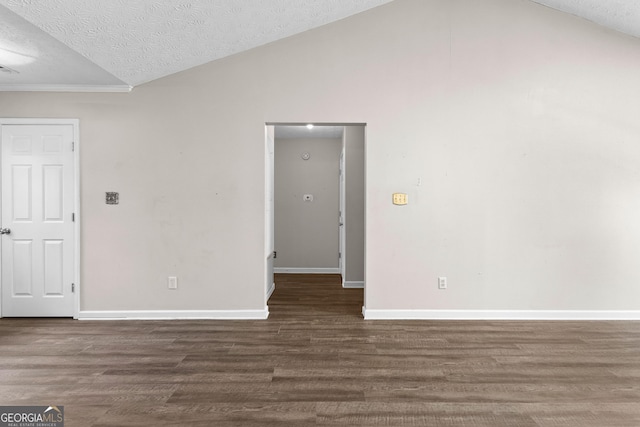 empty room featuring baseboards, a textured ceiling, wood finished floors, and vaulted ceiling