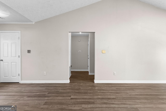 spare room with lofted ceiling, dark wood-type flooring, and a textured ceiling