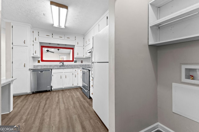 kitchen with appliances with stainless steel finishes, a textured ceiling, wood finished floors, and white cabinetry