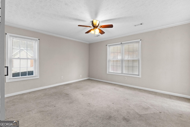 carpeted empty room with ceiling fan, ornamental molding, and a textured ceiling