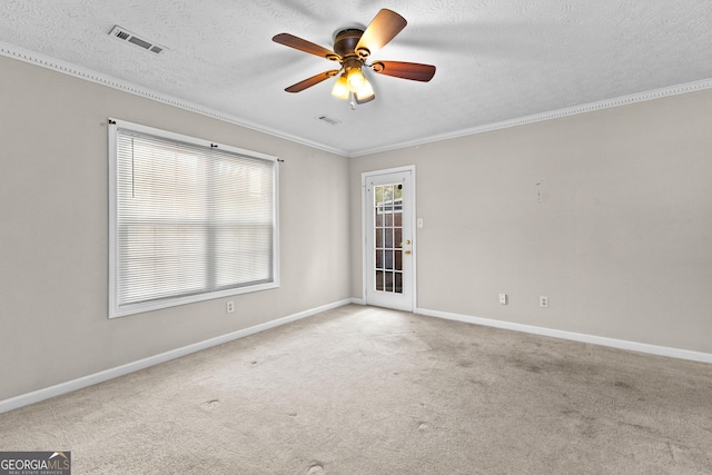 spare room with ceiling fan, visible vents, ornamental molding, and baseboards