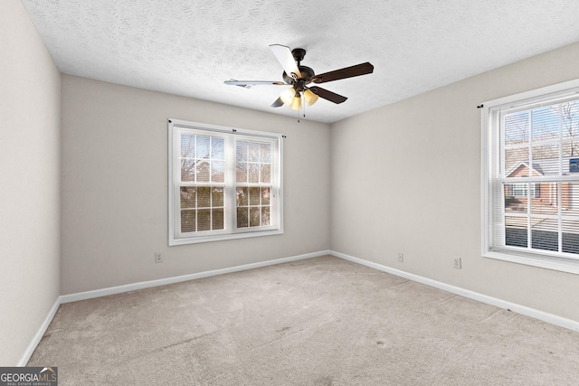 unfurnished room with a textured ceiling, light colored carpet, and ceiling fan