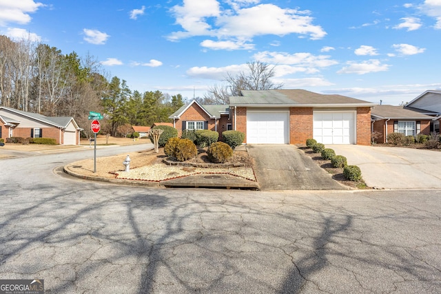 ranch-style home featuring an attached garage, driveway, and brick siding