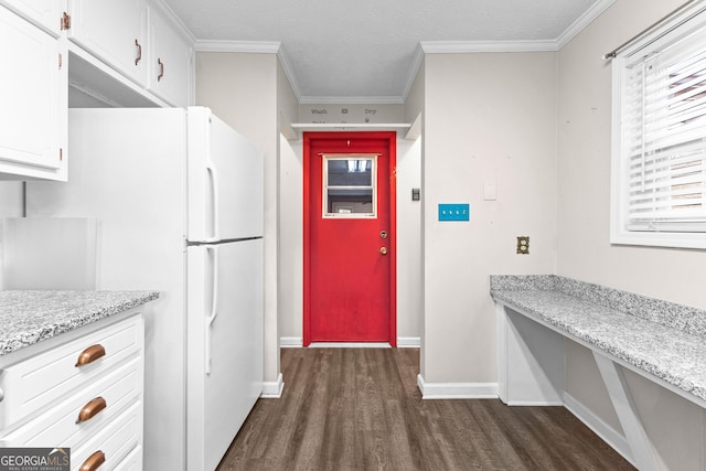 kitchen with white cabinetry, white refrigerator, ornamental molding, dark hardwood / wood-style floors, and light stone countertops