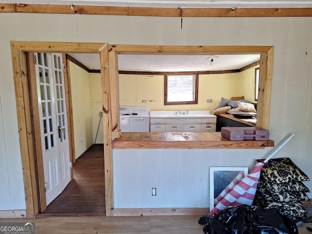 kitchen with crown molding, sink, and hardwood / wood-style floors