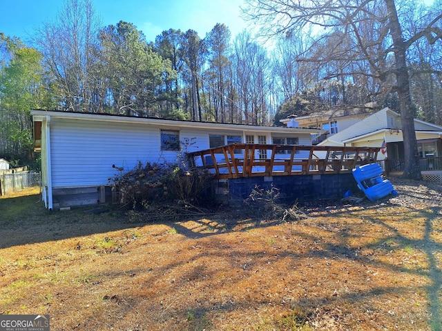 rear view of property featuring a wooden deck