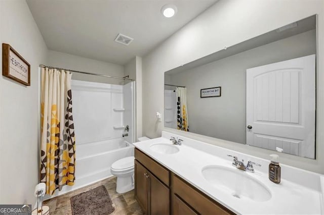 full bathroom featuring vanity, shower / bath combination with curtain, and toilet