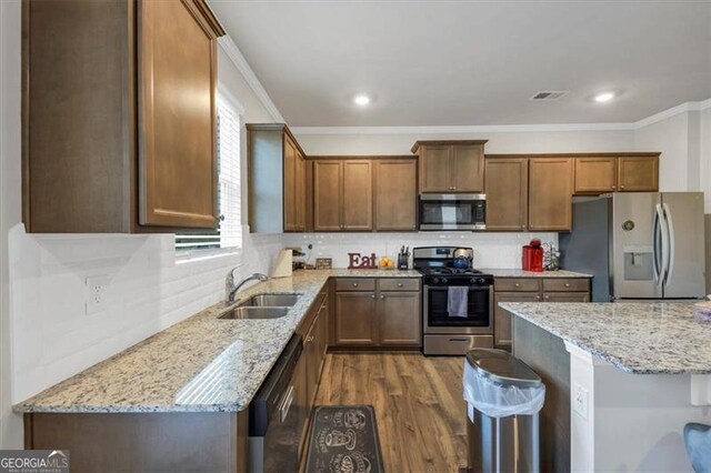 8819 Sibella Ct, Lithia Springs, GA 30122 - kitchen featuring appliances with stainless steel finishes, ornamental molding, light stone countertops, dark wood-style flooring, and decorative backsplash