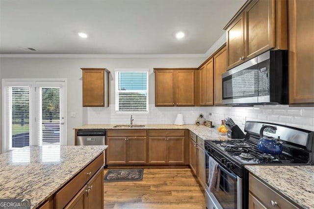 8819 Sibella Ct, Lithia Springs, GA 30122 - kitchen with stainless steel appliances, plenty of natural light, wood finished floors, tasteful backsplash, and ornamental molding