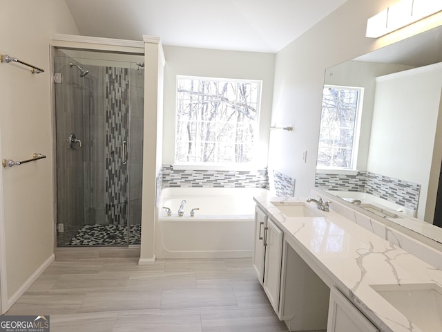 bathroom with vanity, separate shower and tub, and lofted ceiling