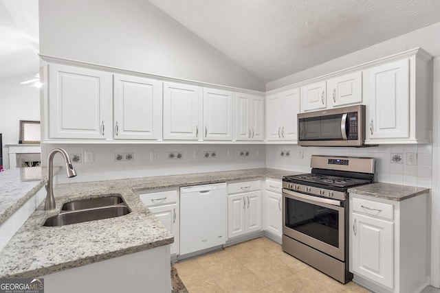 kitchen with vaulted ceiling, white cabinetry, sink, kitchen peninsula, and stainless steel appliances