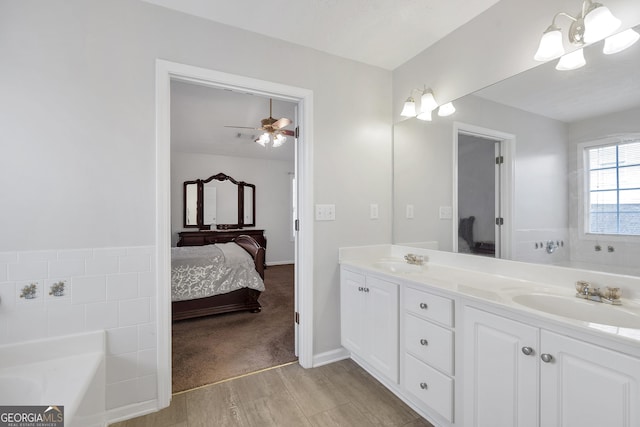 bathroom with vanity, a bathtub, and ceiling fan