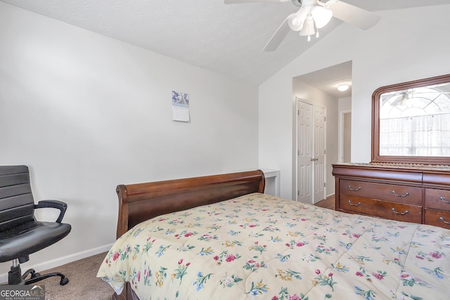 bedroom with ceiling fan, carpet flooring, vaulted ceiling, and a textured ceiling