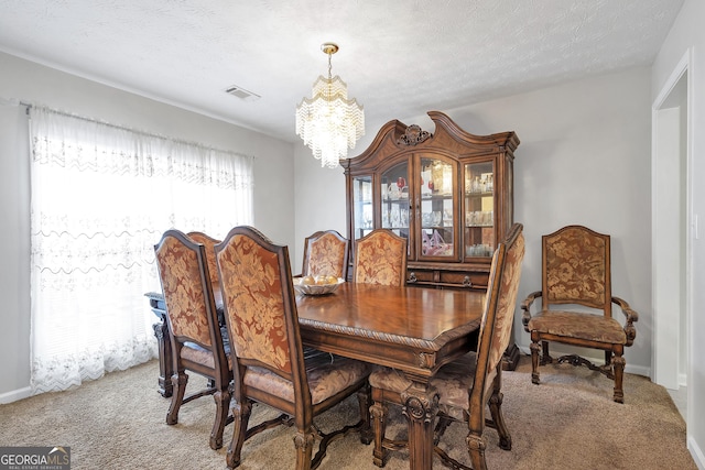 dining area featuring a textured ceiling, carpet floors, and a chandelier