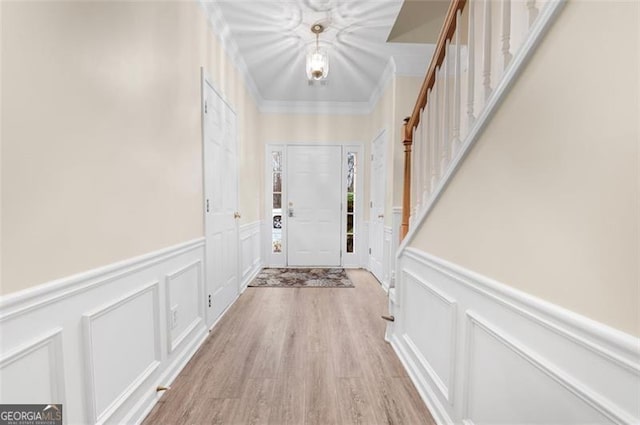 doorway to outside with crown molding and light wood-type flooring