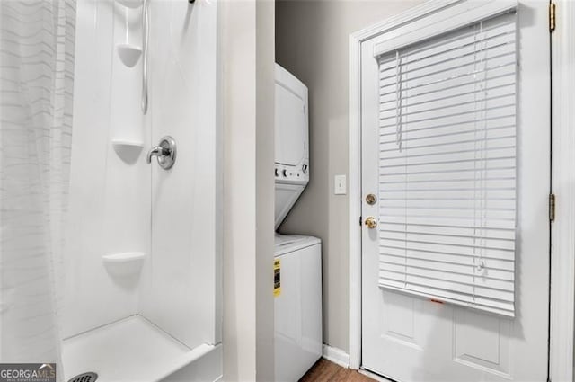 clothes washing area featuring stacked washer and clothes dryer