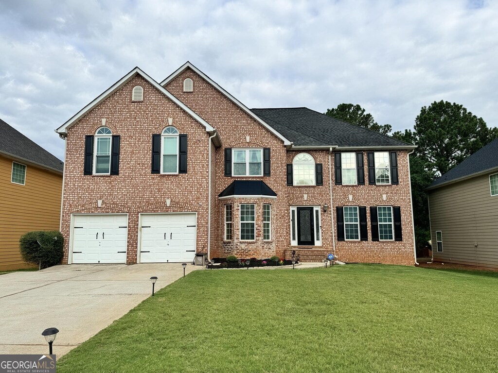 view of front of house with a garage and a front yard