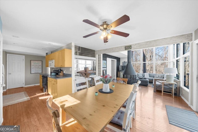 dining space featuring ceiling fan and light wood-type flooring